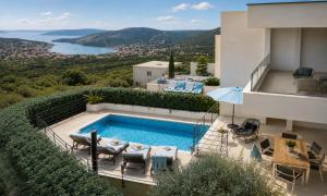 a villa with a swimming pool and a view at Villa Olive Tree in Vinišće