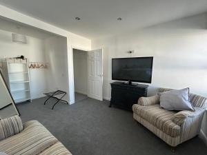 a living room with two couches and a flat screen tv at New Drovers in Llanelli +5 photos
