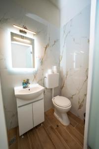 a white bathroom with a toilet and a sink at Penelope - Sea Front Studio in Gouvia +43 photos