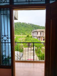 a view from an open door of a balcony at itynnad homestay in Shillong