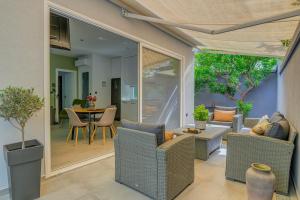 a living room with wicker chairs and a table at Kalafatis Garden House in Itea