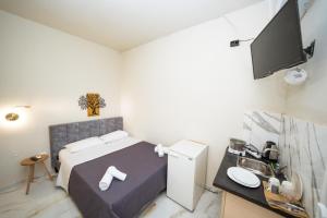 a small bedroom with a bed and a flat screen tv at Penelope - Sea Front Studio in Gouvia