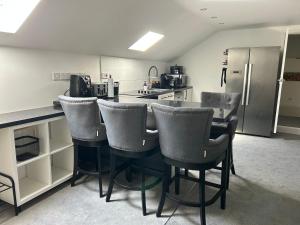 a kitchen with a bar with chairs and a counter at New Drovers in Llanelli