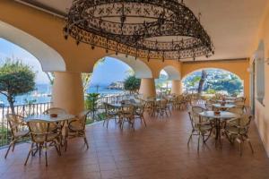 a restaurant with tables and chairs and a chandelier at Hotel Terme Cristallo Palace in Casamicciola Terme