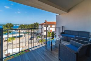 a balcony with a couch and a view of the ocean at Apartments Doris in Malinska