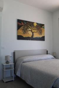 a bedroom with a bed and a painting on the wall at I Tre Ulivi 1 in Mozzate