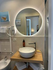 a bathroom with a large white sink and a mirror at Hotel Tirreno in Castiglioncello