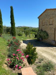 a garden with pink flowers in front of a building at Podere Casanuova in San Gimignano