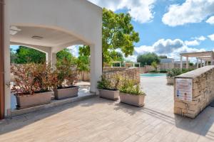 a patio with potted plants and a stone wall at ostuni In suite in Ostuni