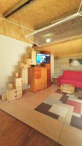 a living room with a red couch and a staircase at A Cabaña do Cumiar in Ponteareas