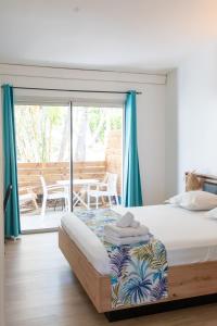 a bedroom with a bed with blue curtains and a patio at Ilot Bleu in Boucan Canot +32 photos