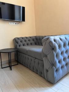 a grey couch in a living room with a table at Chorni vivtsi in Chernivtsi