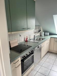 a kitchen with a sink and a stove at Wohnung Ton Strand in Fehmarn