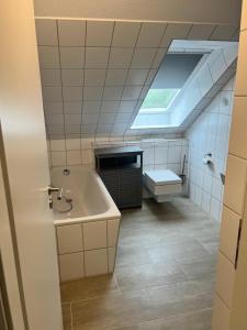 a bathroom with a tub and a sink and a skylight at Wohnung Ton Strand in Fehmarn