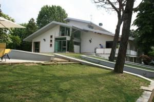 a white house with a tree in front of it at Villa Magnolie in Corbetta