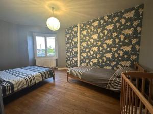 a bedroom with a bed and a wall covered in chickens at Maison de maître in Bressuire