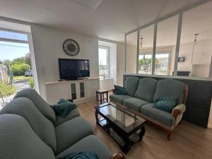 a living room with two couches and a tv at Maison de maître in Bressuire