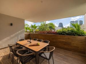 a wooden table and chairs on a balcony with a garden at Luxury Retreat in Puerto Cancun with Rooftop Pool in Cancún