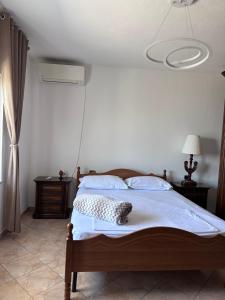 a bedroom with a bed with a white wall at Emerald House Shiroke in Shkodër