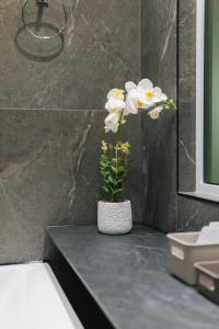 a vase with white flowers on a counter in a bathroom at Lighthouse Nest AXD in Alexandroupoli
