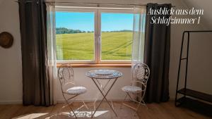 a table and two chairs in front of a window at Idyllische Ferienwohnung im Kalletal in Kalletal