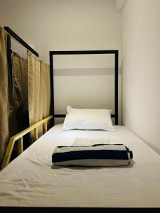 a bed with a black and white blanket on it at Wake N Flow, Arugam Bay in Arugam Bay