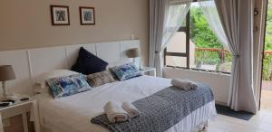 a bedroom with a bed with towels on it at Sunbirds Bed & Breakfast in Southbroom