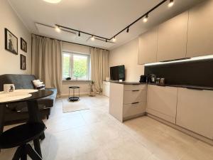 a living room with a kitchen and a dining room at Apartament Kopalniok II in Zabrze