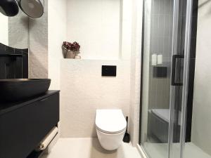 a bathroom with a toilet and a glass shower at Apartament Kopalniok II in Zabrze