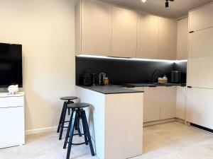 a kitchen with a counter and stools in it at Apartament Kopalniok II in Zabrze