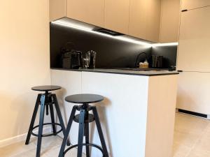 a kitchen with two stools and a counter top at Apartament Kopalniok II in Zabrze +21 photos