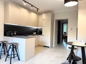 a kitchen with a counter and some tables and stools at Apartament Kopalniok II in Zabrze