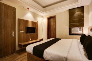 a bedroom with a large bed and a television at Collection O Stargaze in Kānpur