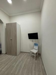 a room with a tv and a chair and a cabinet at MareLuna in Torre del Greco