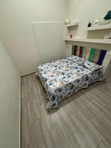 a bedroom with a bed with a floral comforter at MareLuna in Torre del Greco