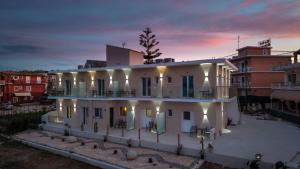 a large white building with a sunset in the background at Penelope - Sea Front Studio in Gouvia