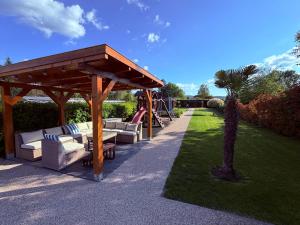 a wooden gazebo with couches and a playground at DIÓFA APARTMAN in Pilismarót