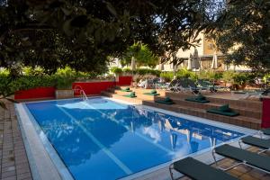 a large swimming pool with lounge chairs at AQUA Hotel Bertran Park in Lloret de Mar