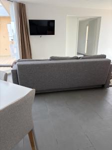 a living room with a couch and a tv at Attico Terracotta in Borgo Bainsizza