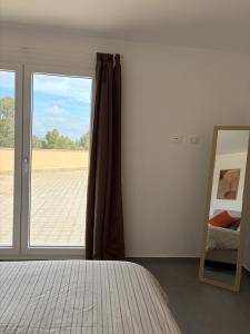 a bedroom with a bed and a large window at Attico Terracotta in Borgo Bainsizza