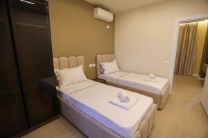 two beds in a small room with a mirror at Blue Coast - Villa 1 Perla Resort in Lalëz