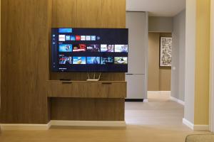 a living room with a flat screen tv on a wooden entertainment center at Blue Coast - Villa 1 Perla Resort in Lalëz