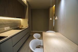 a kitchen with a wooden table and white chairs at Blue Coast - Villa 1 Perla Resort in Lalëz +41 photos