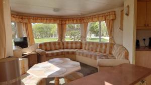 a living room with a couch and a table at Sanderling Bluebird 14 in Cruden Bay