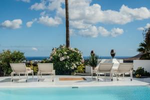 a group of chairs sitting next to a pool at Villa Lore by Villalize in Teguise