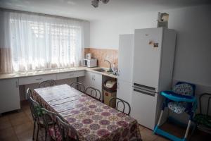 a kitchen with a table and a white refrigerator at Casa Albă in Sănduleşti
