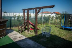 a swing set in a yard with a playground at Casa Albă in Sănduleşti