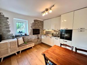 a kitchen with white cabinets and a wooden table at Da Ö NOXE in Bracco