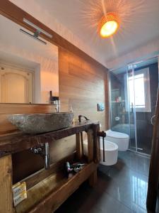 a bathroom with a stone sink and a tub at Da Ö NOXE in Bracco