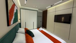 a bedroom with a bed and a flat screen tv at Zafran Smart Luxury Suite in Dushanbe +16 photos